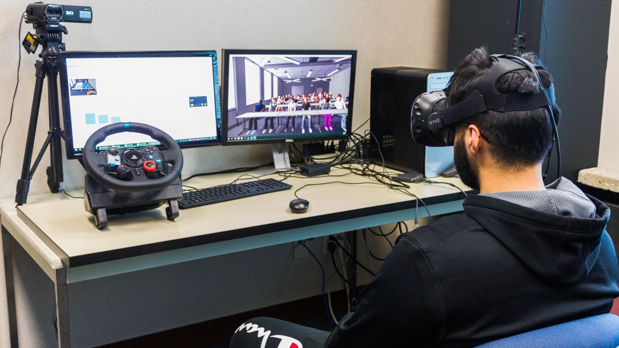 Une personne assise avec un casque de réalité virtuelle.