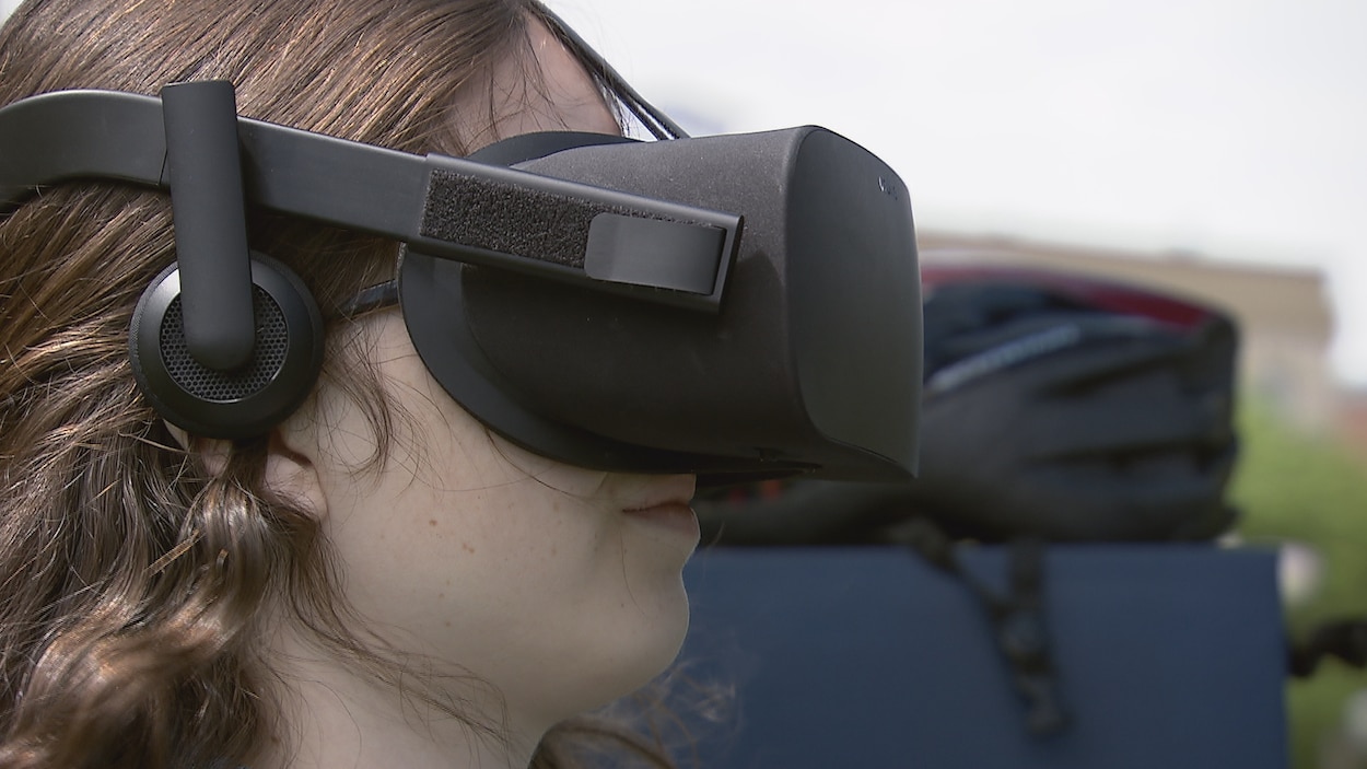 Une jeune conductrice participe à la simulation après avoir enfilé un casque de réalité virtuelle. Une jeune conductrice participe à la simulation après avoir enfilé un casque de réalité virtuelle.