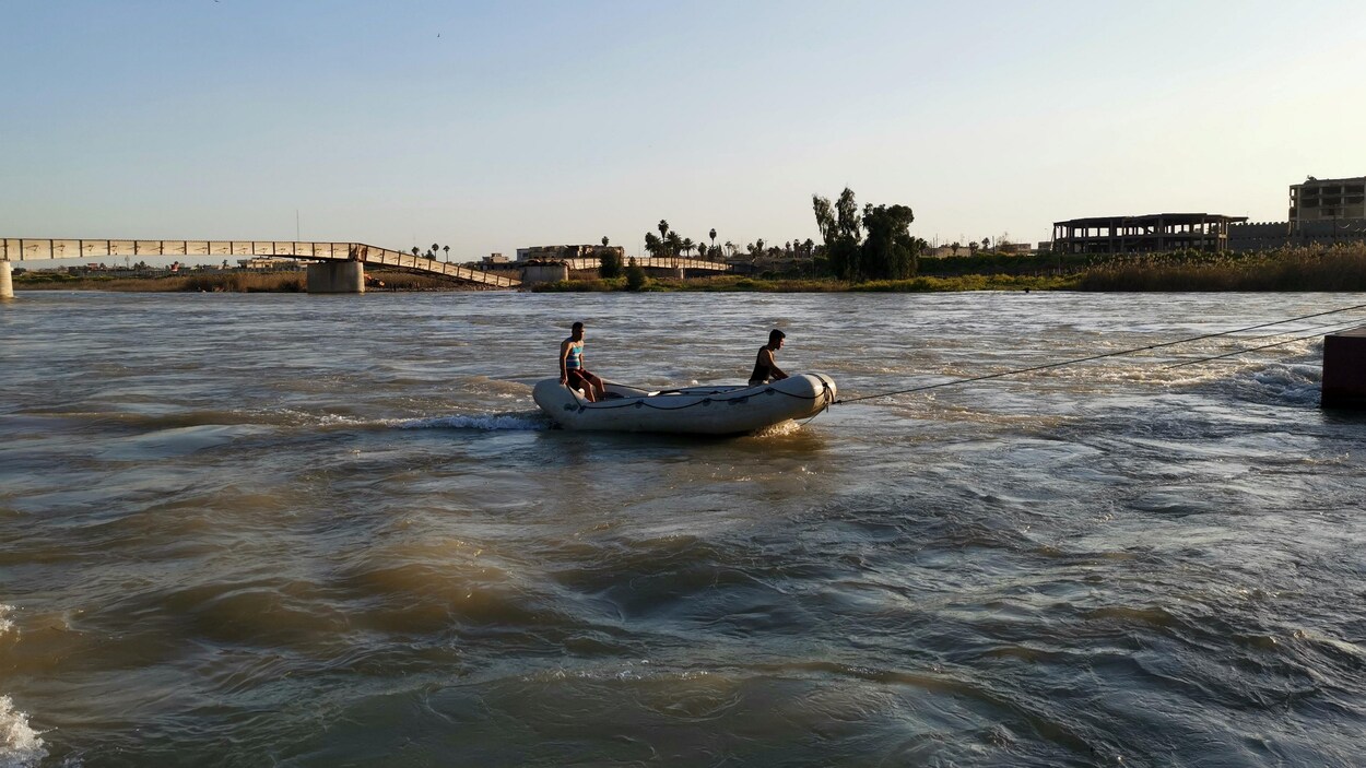 Deux secouristes sur un bateau pneumatique sur le Tigre, à Mossoul.