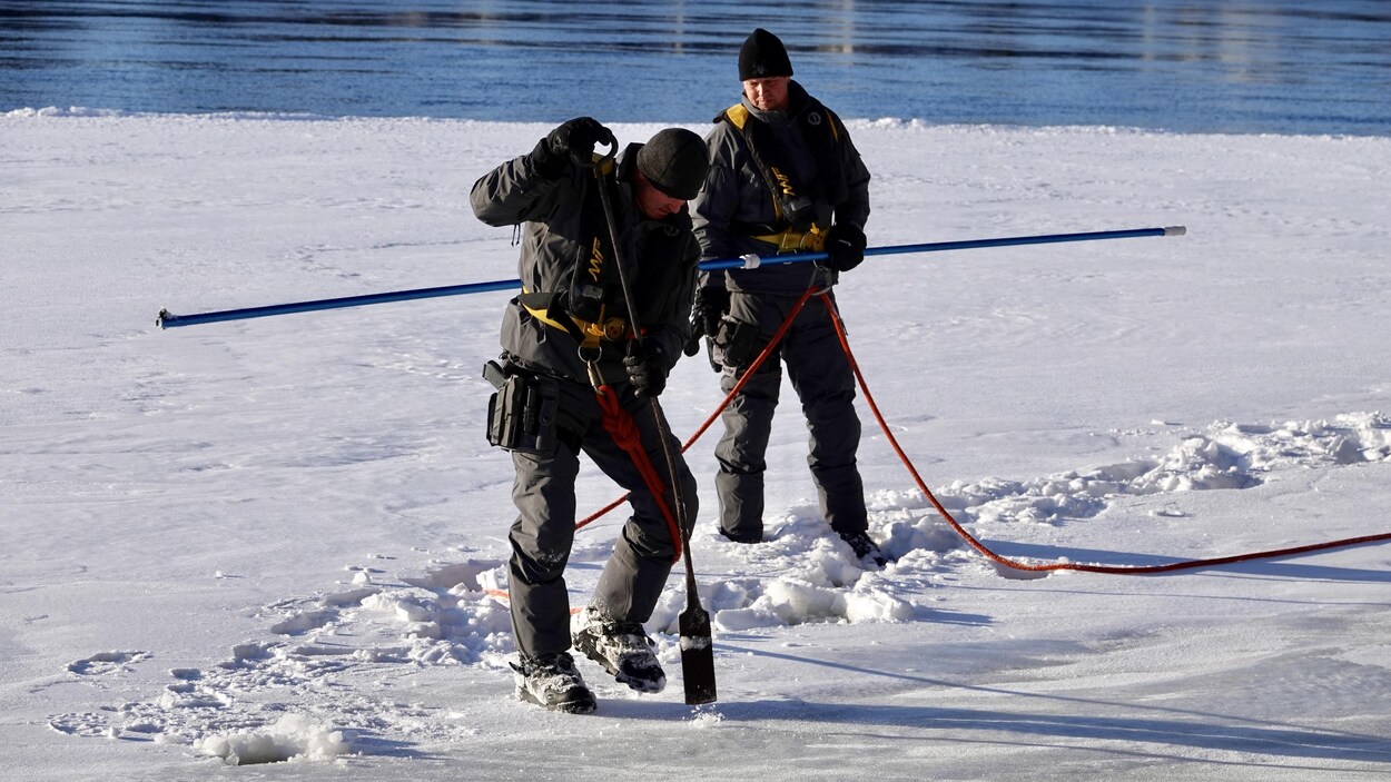 Un homme pique la glace pour en évaluer l'épaisseur Un homme pique la glace pour en évaluer l'épaisseur