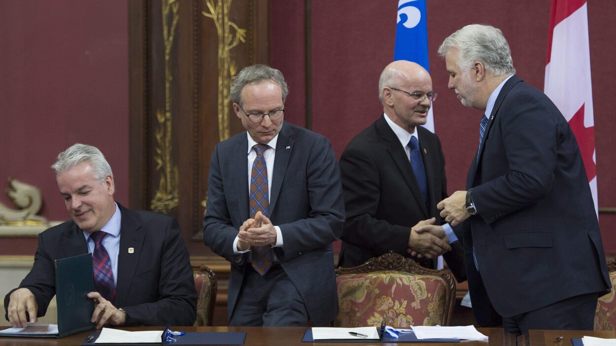 Bernard Sévigny, président de l'Union des municipalités du Québec, Martin Coiteux, ministre des Affaires municipales du Québec, Richard Lehoux, président de la Fédération des municipalités du Québec, et Philippe Couillard, premier ministre du Québec