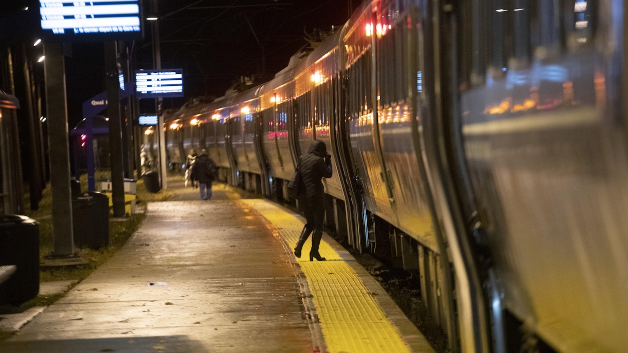 Une femme entre dans un train qui s'apprête à quitter la gare de Deux-Montagnes.