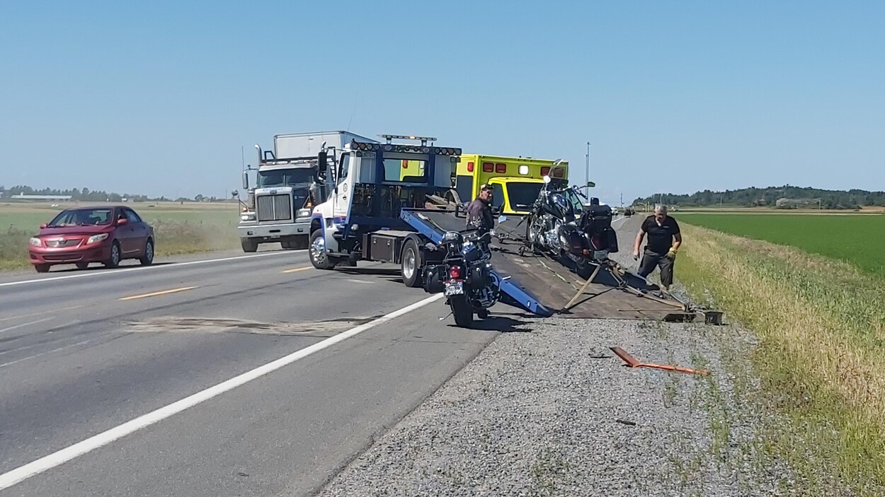 Une motocyclette se trouve à l'arrière d'un camion de remorquage.