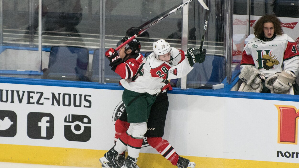 Un joueur de chaque équipe se rentre dedans pendant un match entre les Remparts de Québec et les Mooseheads d'Halifax au Centre Vidéotron.
