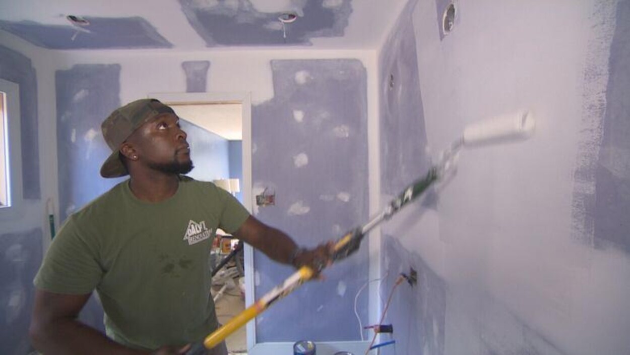 Un homme peint un mur.