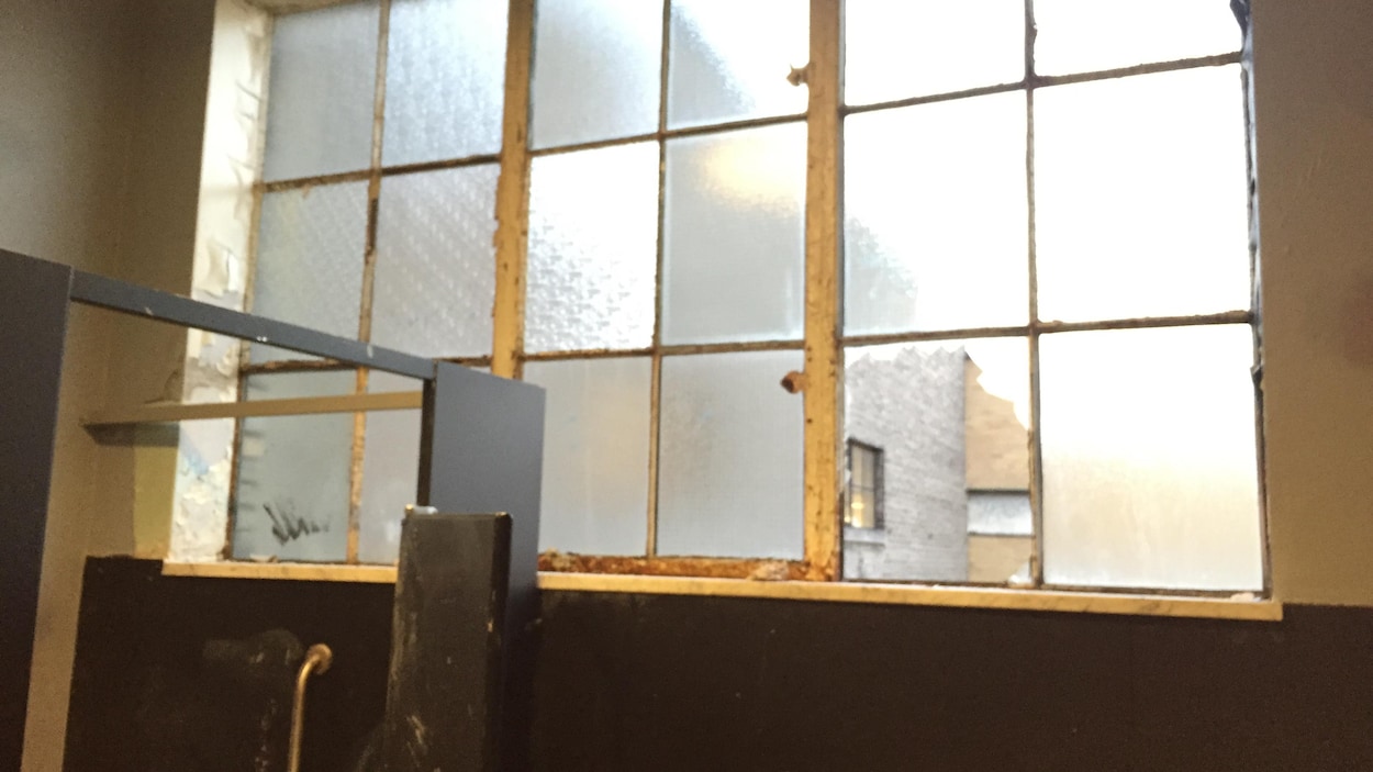 De vieilles fenêtres dans une salle de toilettes. Un des carreaux des fenêtre est brisé. De vieilles fenêtres dans une salle de toilettes. Un des carreaux des fenêtre est brisé.
