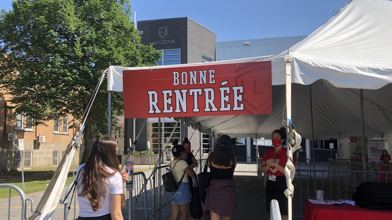 Des étudiantes font la file sous une tente dressée devant le Collège Laflèche.