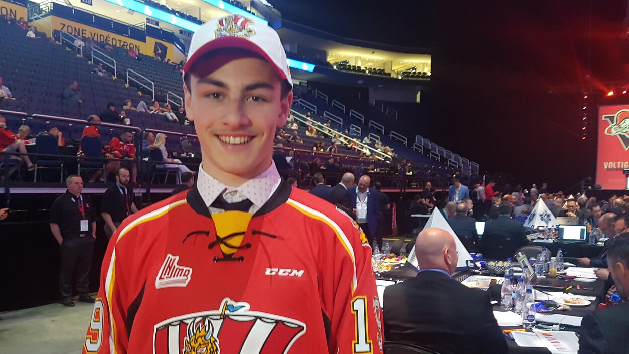 Il vient d'enfiler le chandail numéro 19 du Drakkar et la casquette de l'équipe.