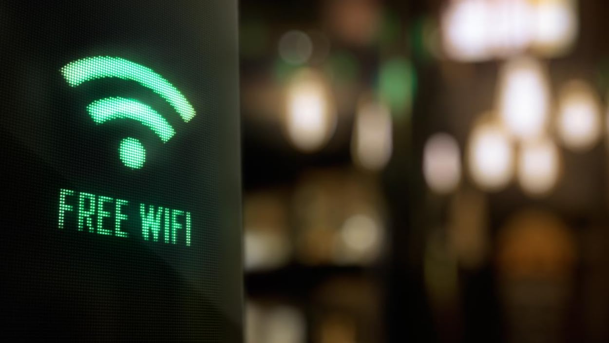 Un affichage lumineux vert sur un écran noir affiche la mention « free wifi » (wifi gratuit). Un affichage lumineux vert sur un écran noir affiche la mention « free wifi » (wifi gratuit).