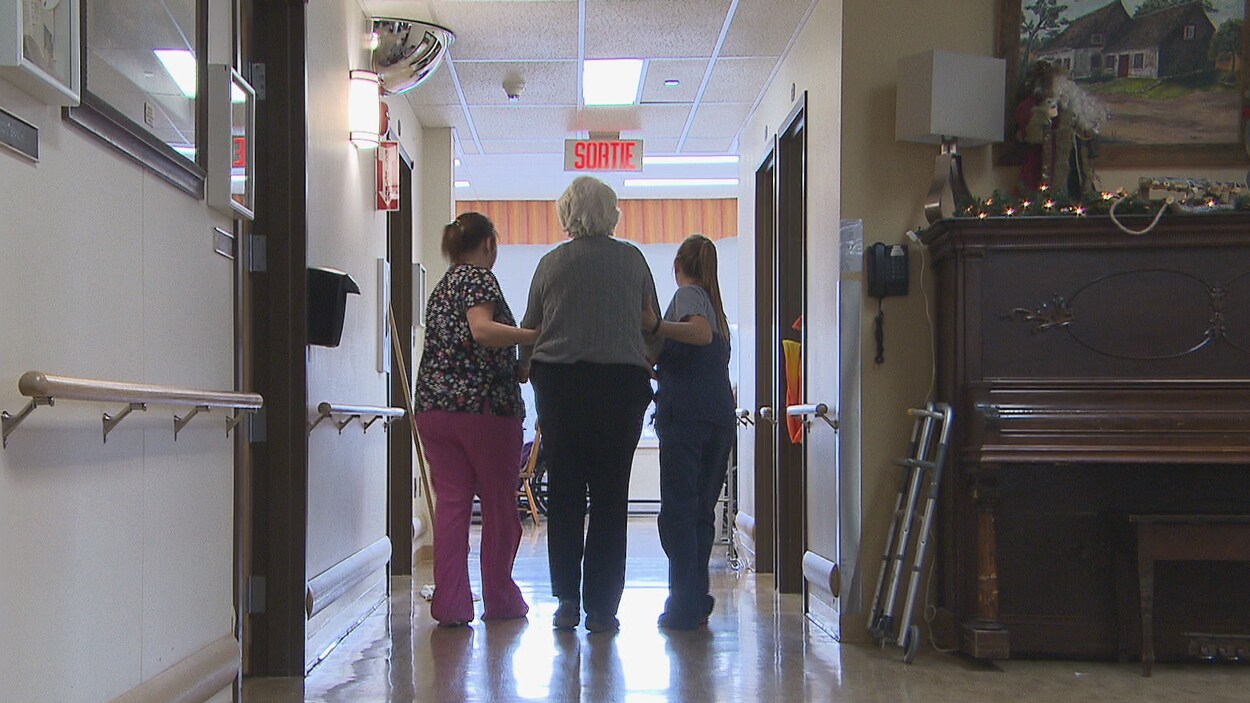 Deux employés de la résidence Wales Home qui accompagnent une résidente