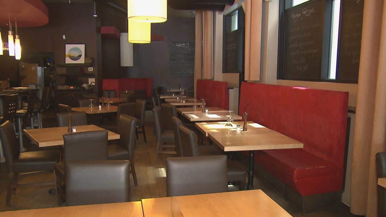Un salle de restaurant vide avec plusieurs tables.