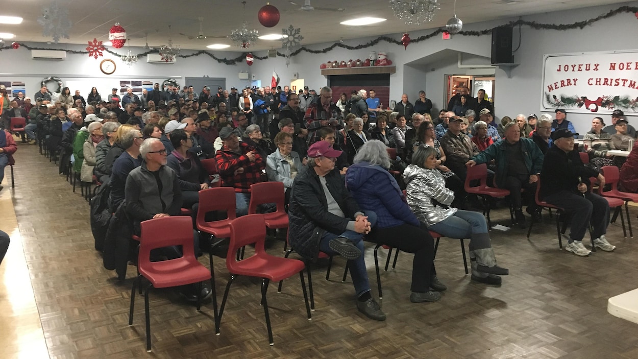 Une salle communautaire remplie de participants.