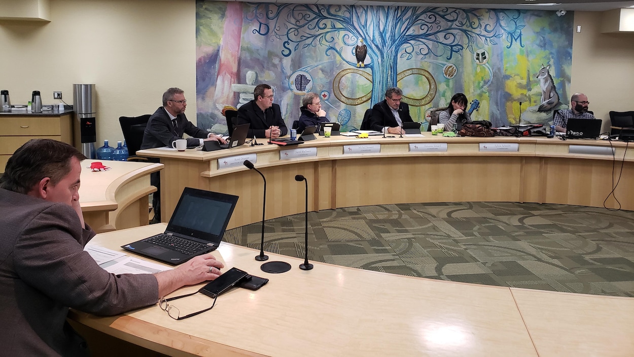 Des participants assis à leurs bureaux pendant une rencontre.
