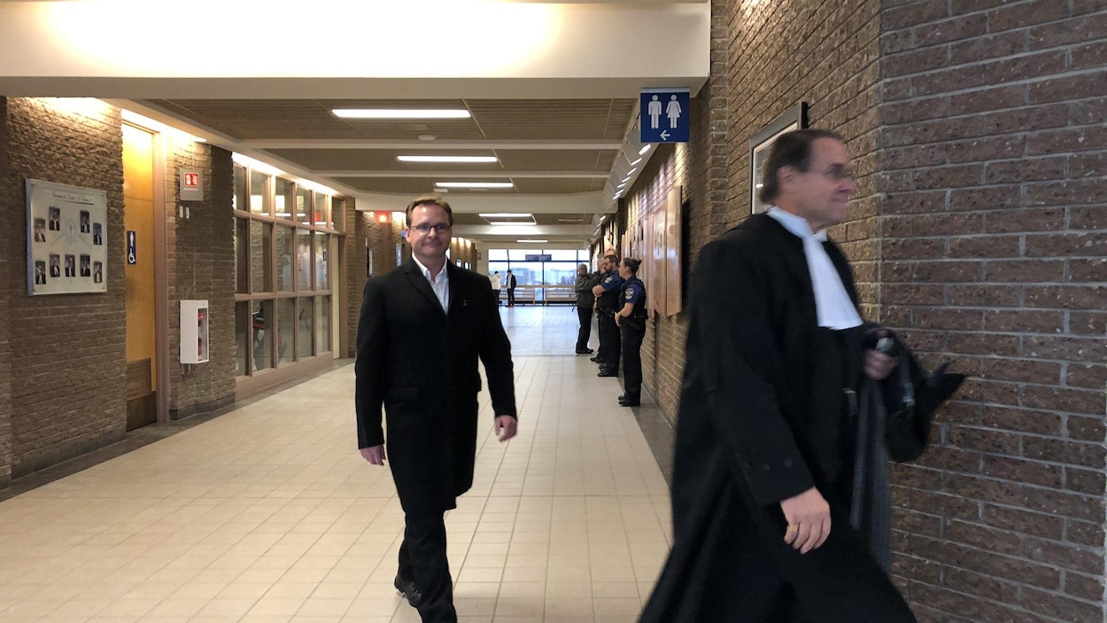 L'homme, léger sourire au visage, se rend en cour.