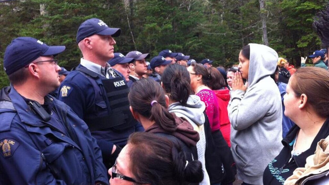 Policiers et manifestants face à face sur une route.