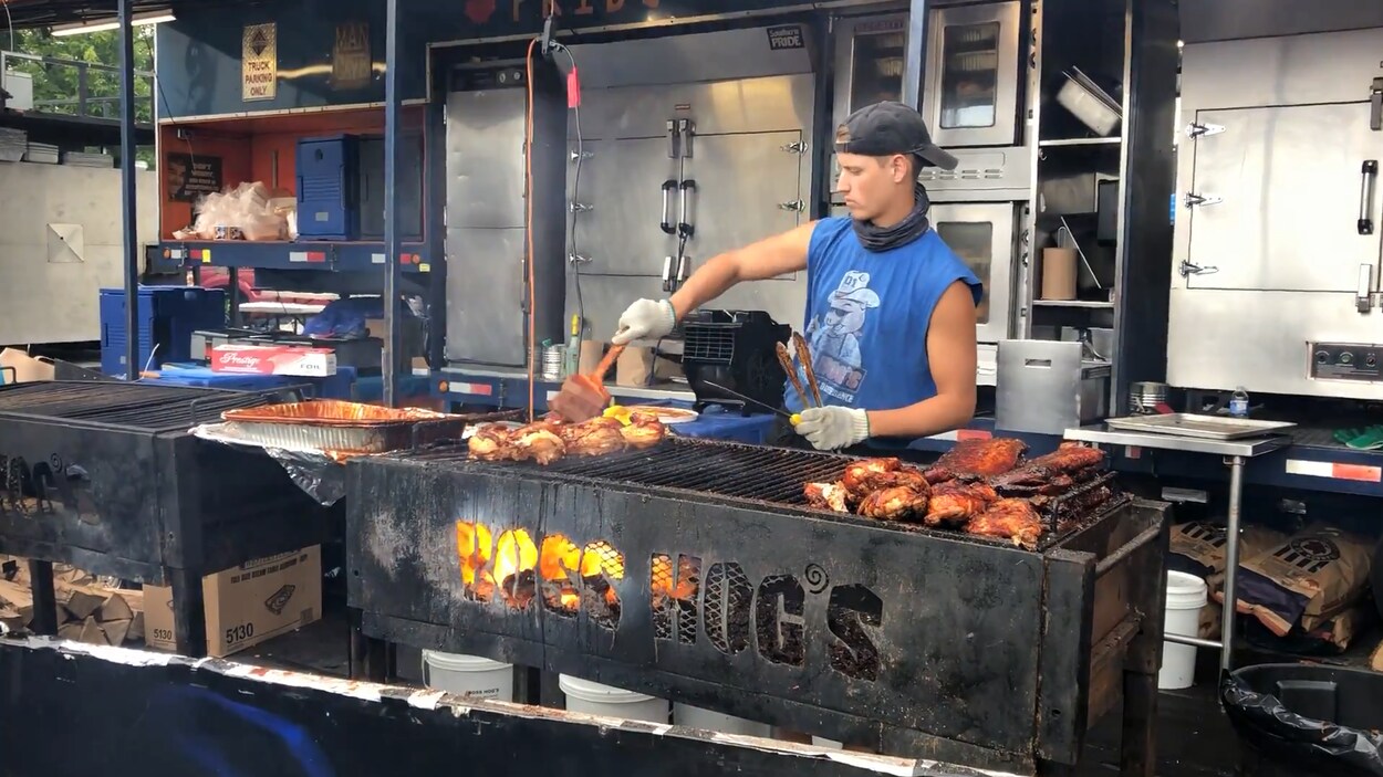 Un homme recouvre de la viande de sauce BBQ.