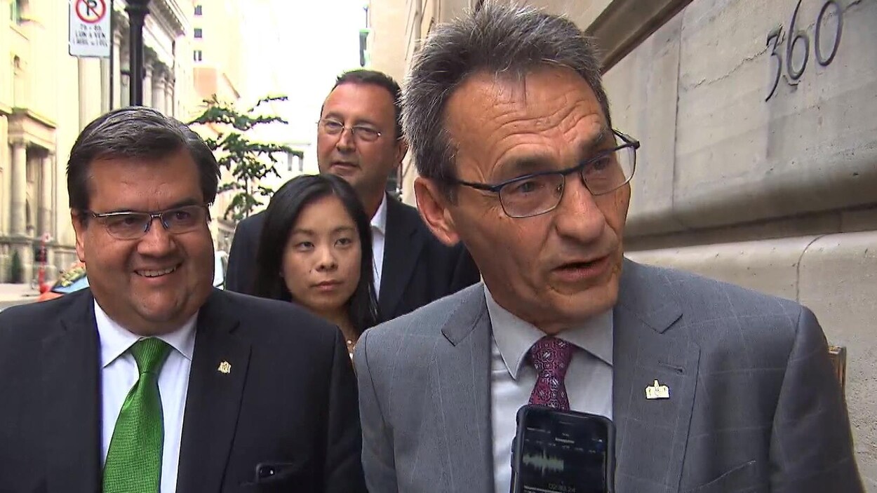 Le candidat Richard Bergeron en compagnie du maire sortant Denis Coderre, en point de presse à Montréal. À l'arrière, on voit les autres candidats dans l'arrondissement de Ville-Marie, Cathy Wong et Pierre Mainville.