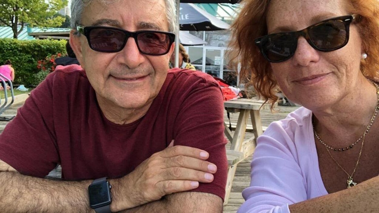 Le couple est souriant, sur une terrasse.