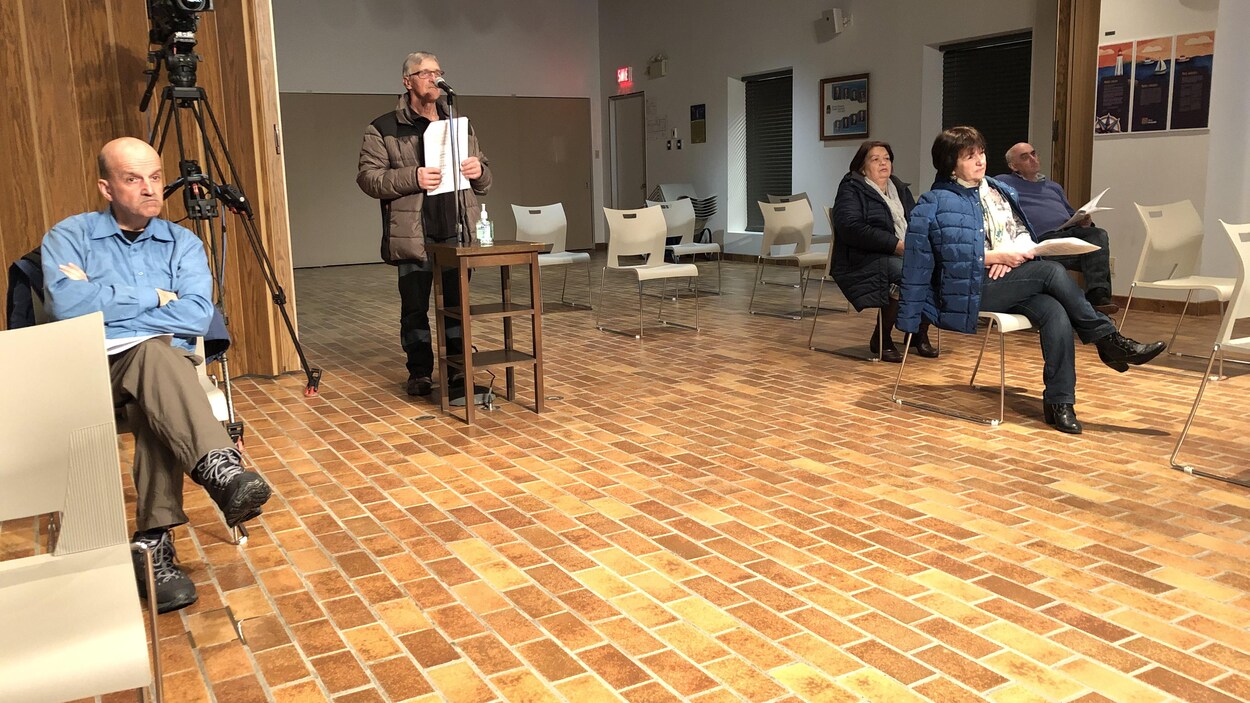 Des gens assis sur des chaises dans la salle du conseil municipal de Rimouski.
