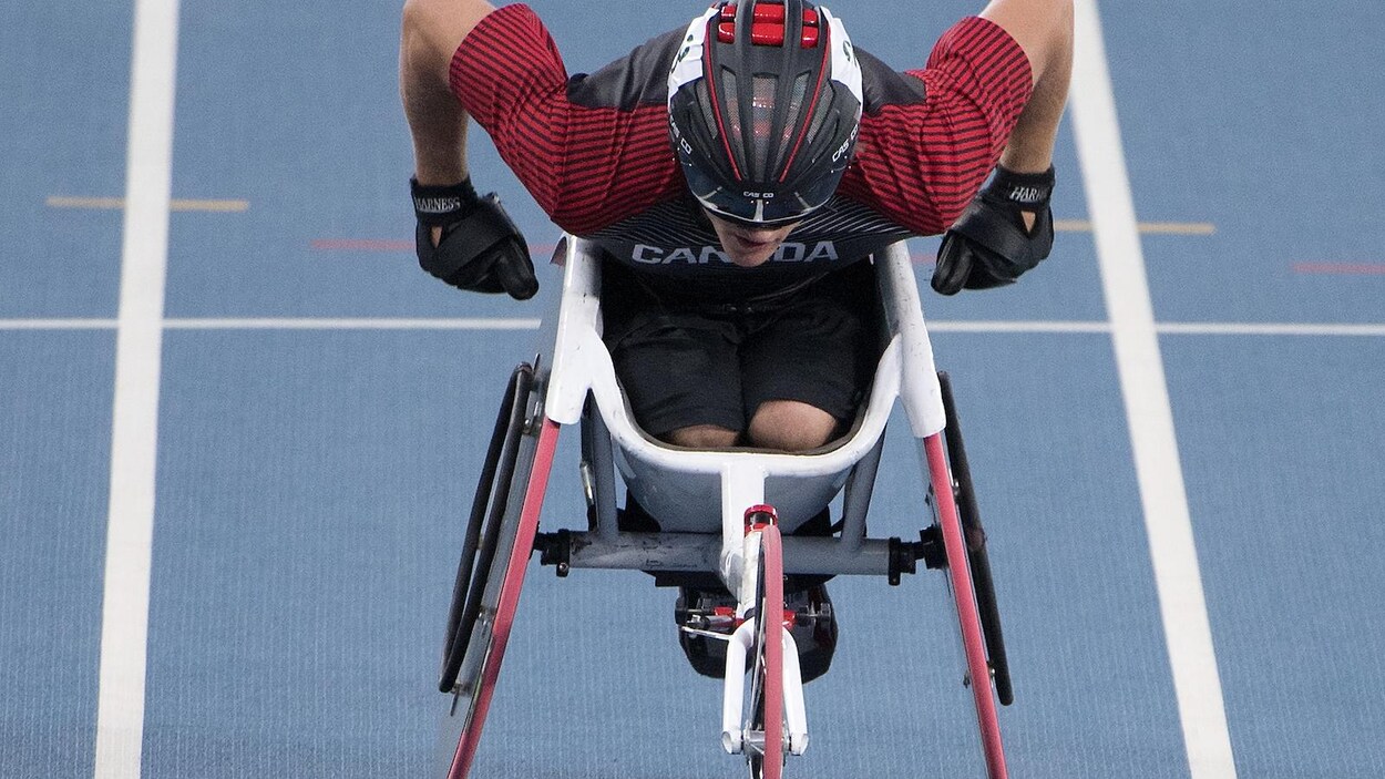 Un homme en fauteuil roulant lors d'une compétition sur piste. 