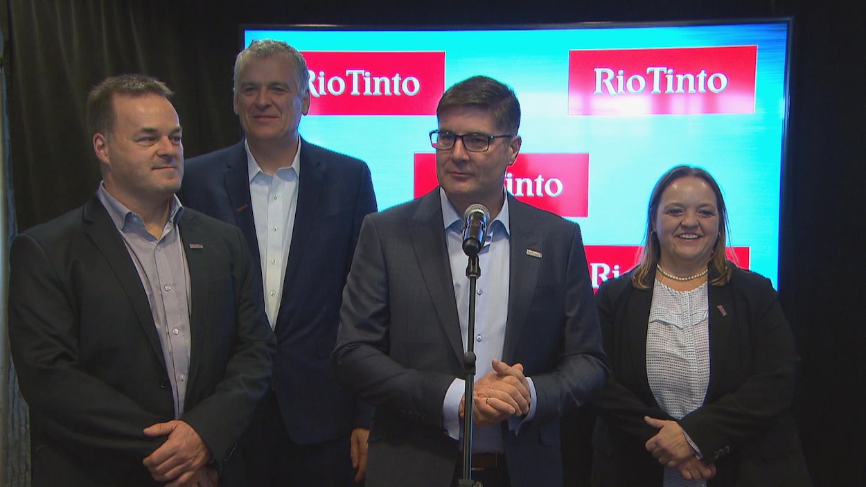 Quatre dirigeants de Rio Tinto répondent aux questions des journalistes devant un micro.
