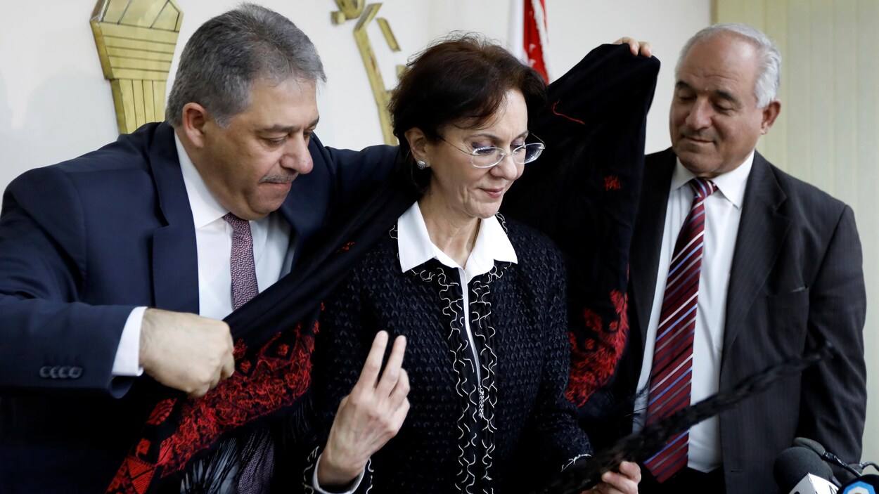 L’ambassadeur palestinien au Liban, Ashraf Dabbour, aide Rima Khalaf, secrétaire générale adjointe des Nations unies à revêtir un châle traditionnel palestinien après l’annonce de la démission de cette dernière à Beyrouth, le 17 mars 2017