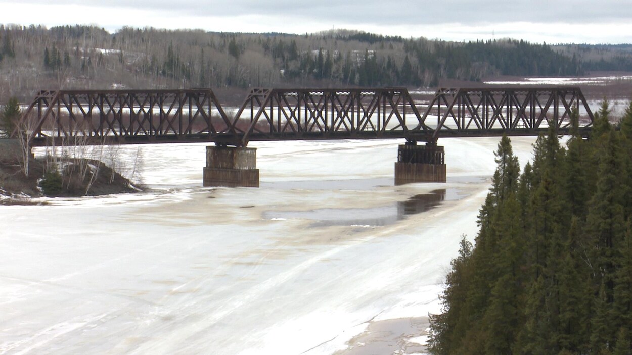 Une rivière traversée par un vieux pont ferroviaire fond au printemps.