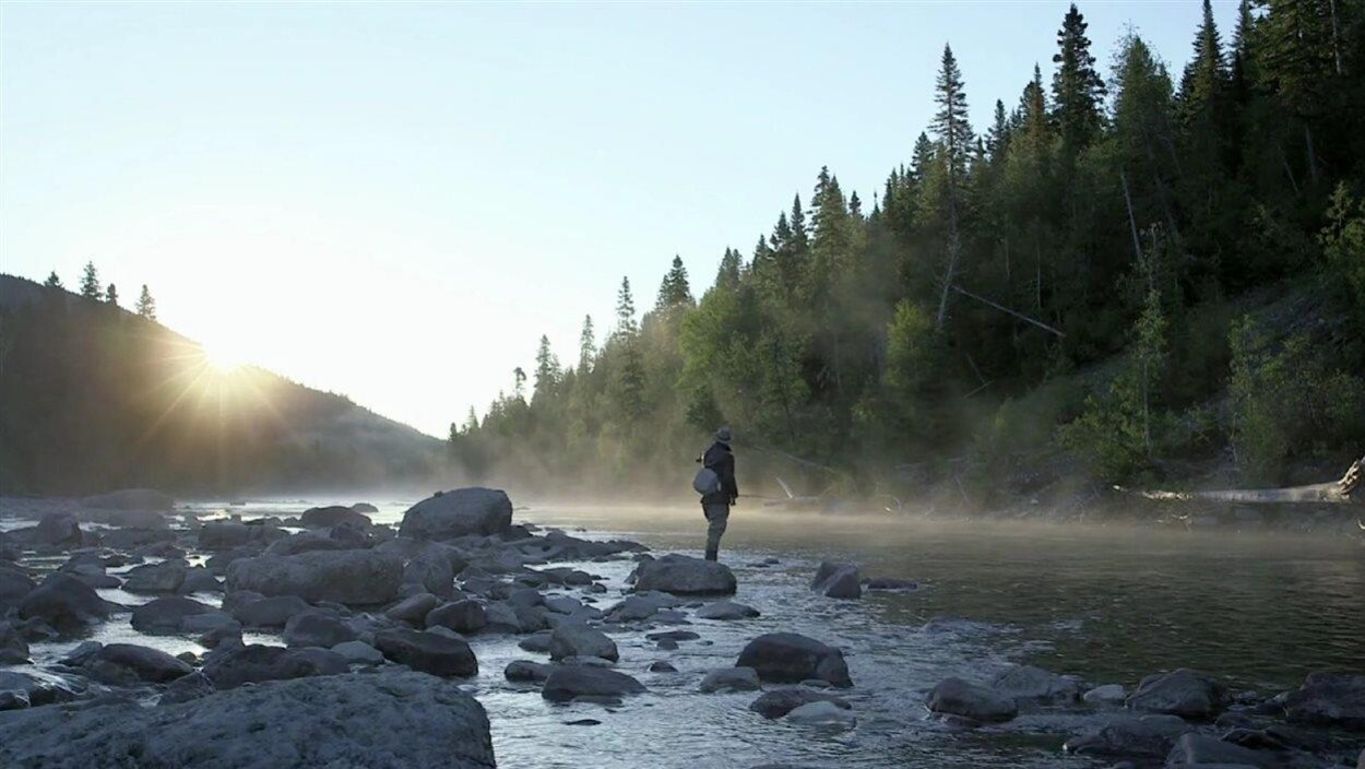 Personne debout sur une pierre au bord de la rivière Matapédia. Personne debout sur une pierre au bord de la rivière Matapédia.