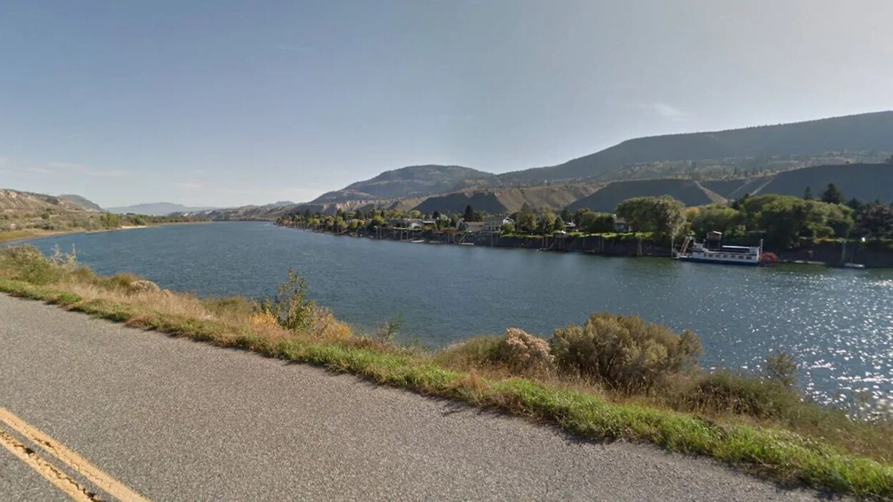 La rivière Thompson Sud au bord d'une route avec au loin un bateau et des collines.