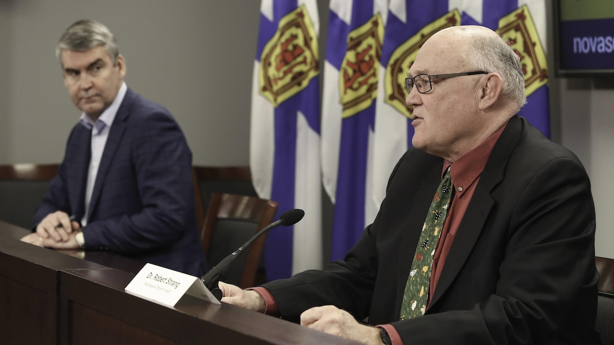 Le profil gauche de Robert Strang et Stephen McNeil qui le regarde de loin.