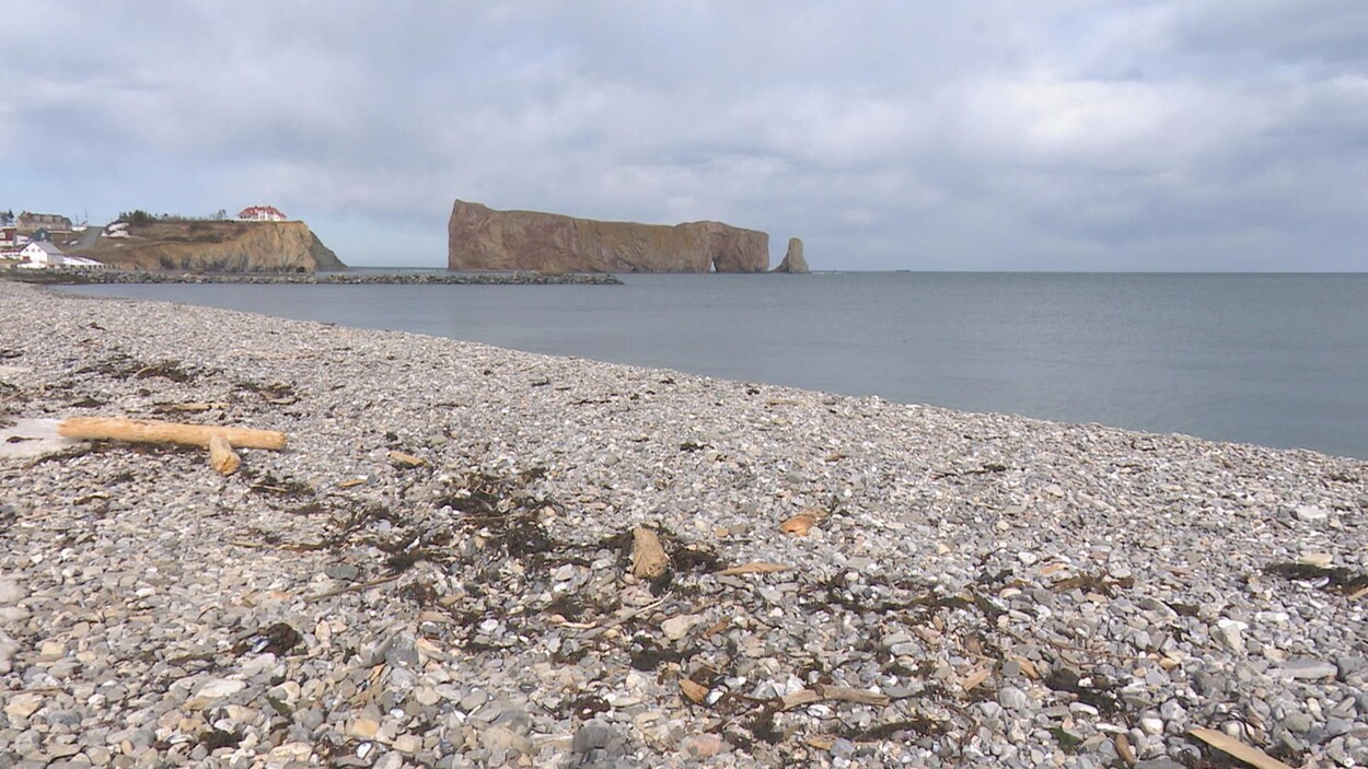 On aperçoit le rocher au loin, avec la plage en avant-plan.