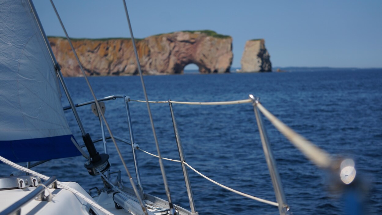 Le rocher Percé au loin, vu du pont d'un voilier