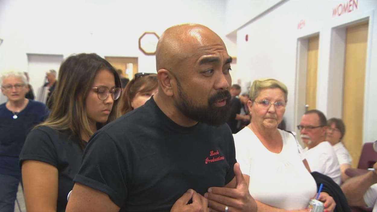 Un homme barbu avec un t-shirt noir.