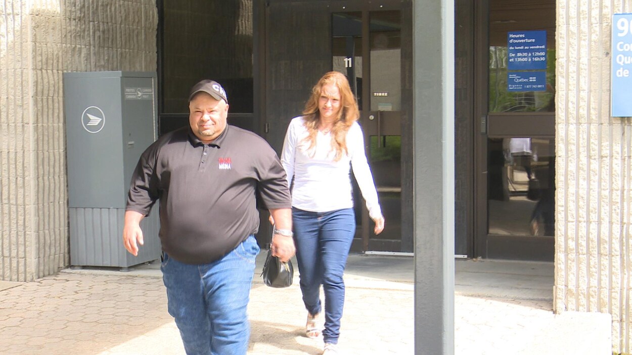 Un homme portant un chandail de 10-04 Média et une femme sortent du palais de justice d'Amos.