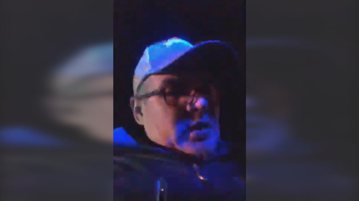 Rodrigue Wapistan regarde sa caméra. Il fait noir et il y a des lumières de police.