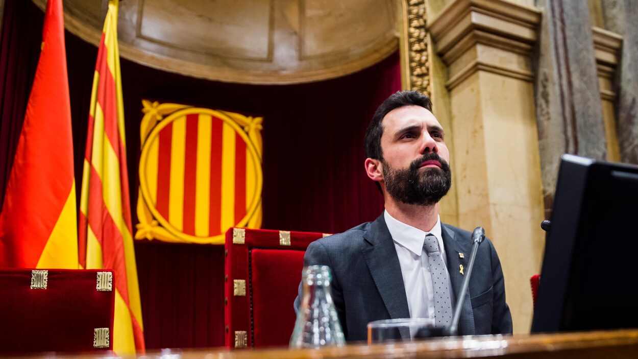 Le politicien espagnol Roger Torrent est assis derrière un bureau. Il a un air sérieux.