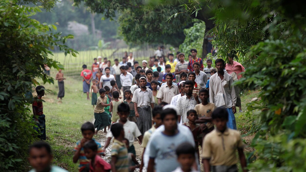 Cette photo prise en octobre 2016 montre des Rohingyas marchant dans un village situé près de Maungdaw, dans le nord de l'État d'Arakan.