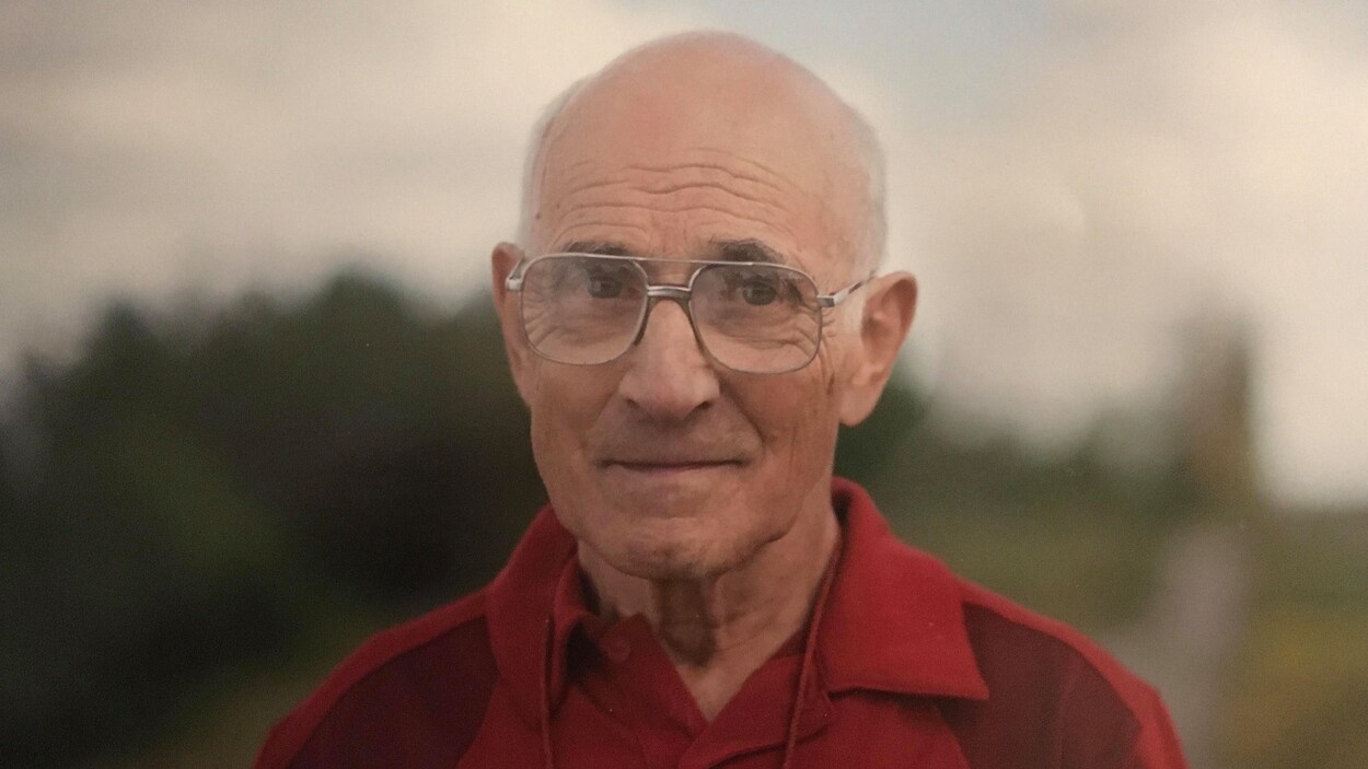 Un homme aux cheveux gris avec des lunettes.