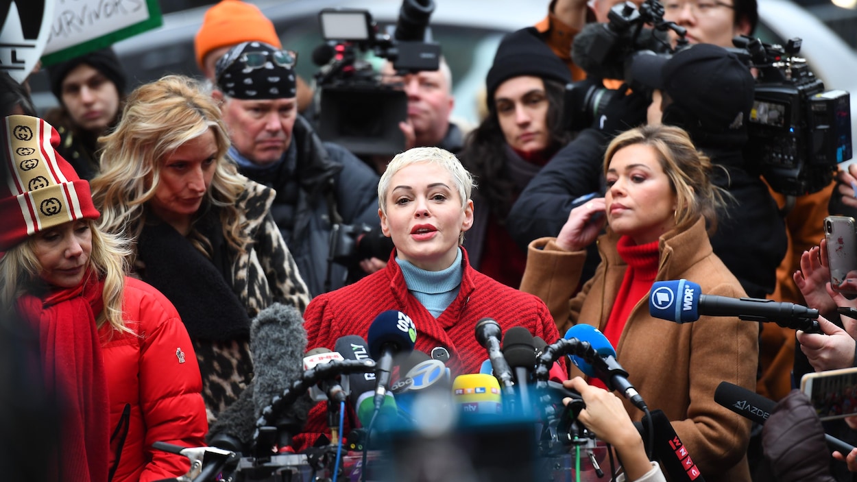 Entourée de femmes, Rose McGowan prend la parole au micro et s'adresse aux médias.