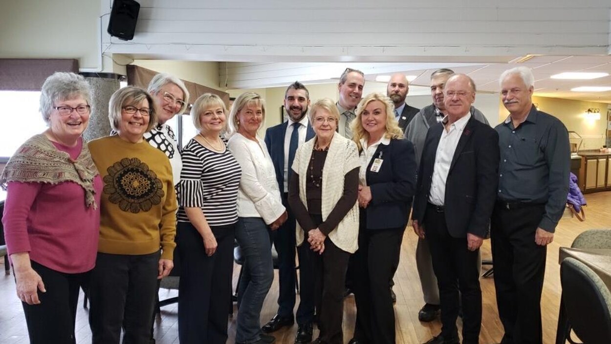 Ross Romano pose pour une photo avec des résidents et employés d'un centre de soins de longue durée.