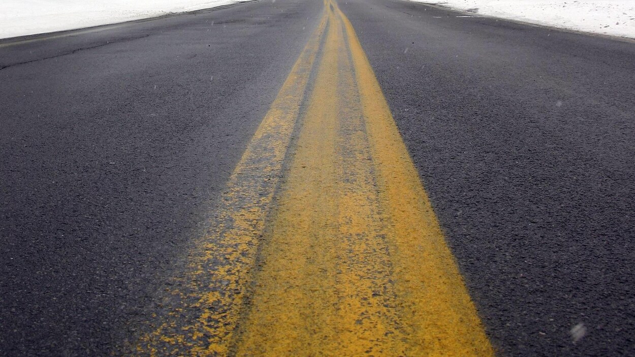 Ligne jaune peinte au milieu d'une route.