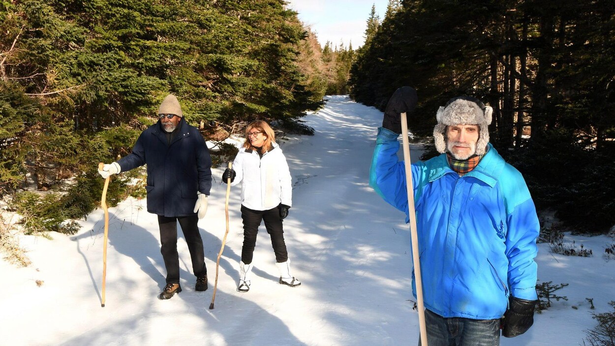 Gene Kersey, Heather Hayes et Tim Menk sur la route enneigée bordée d'arbres.
