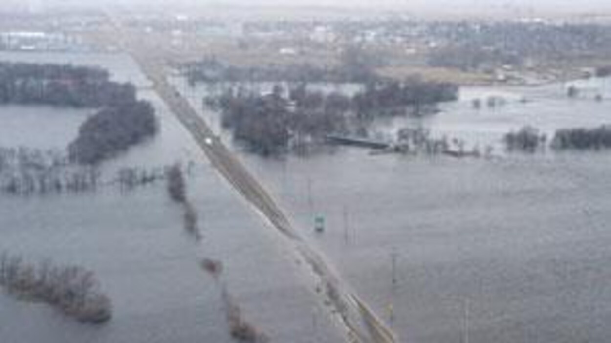 Une route et des champs inondés.
