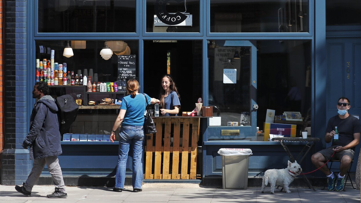 Des gens dans une rue à Londres devant un comptoir-restaurant.
