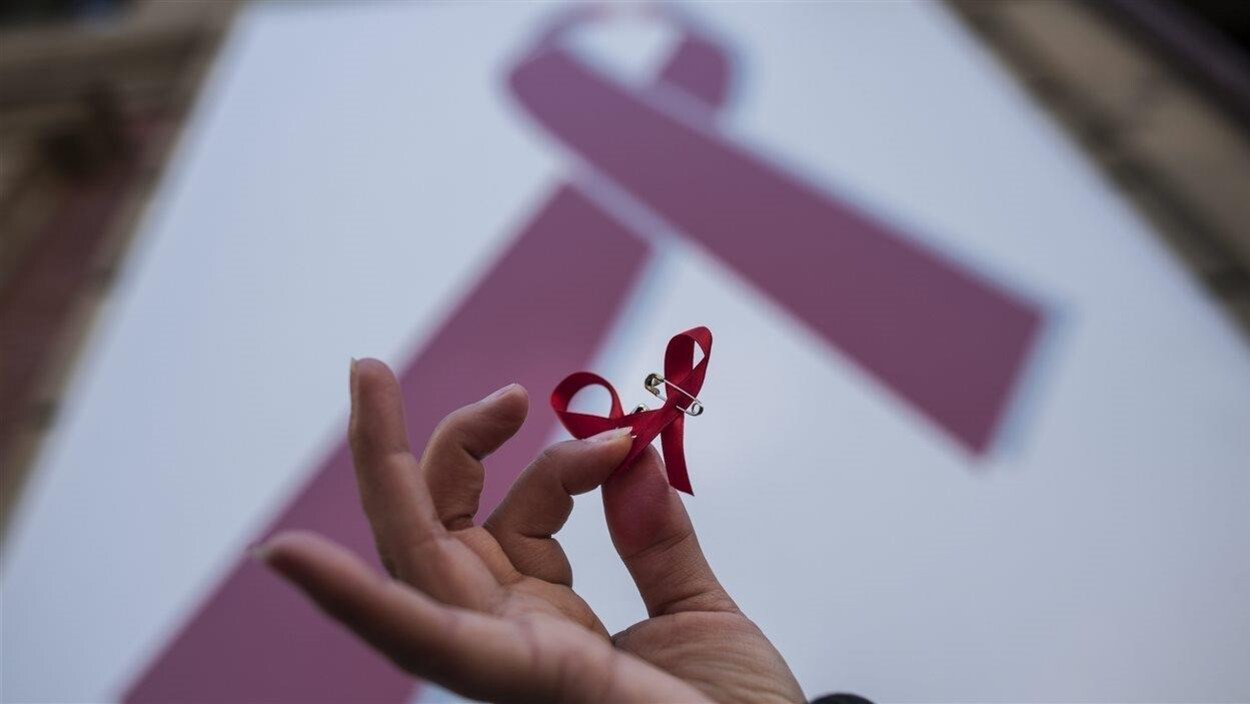 Une femme tient dans ses mains un ruban rouge.