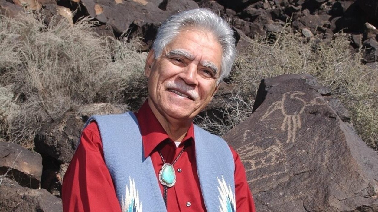Rudolfo Anaya prend la pose près de pétroglyphes, au Nouveau-Mexique.