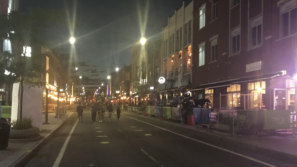 Des gens marchent sur la rue des forges ignorant l'avis de confinement