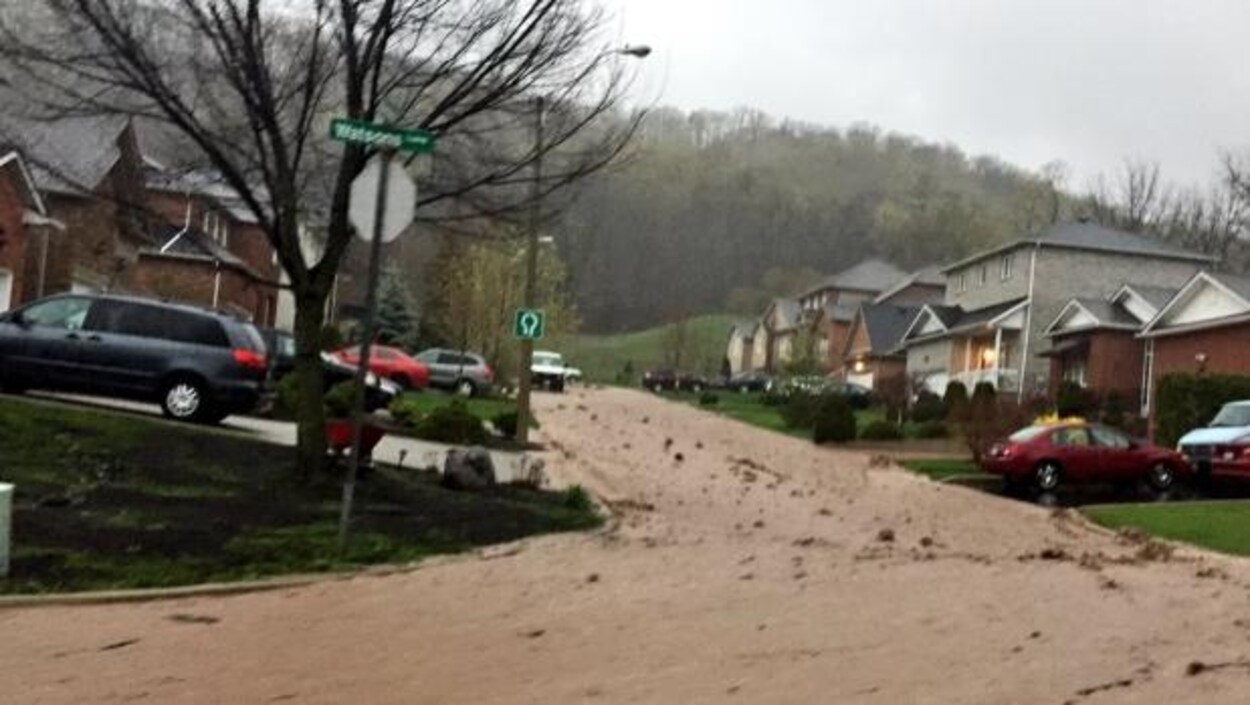L'eau s'écoule le long d'une rue du secteur Dundas à Hamilton L'eau s'écoule le long d'une rue du secteur Dundas à Hamilton