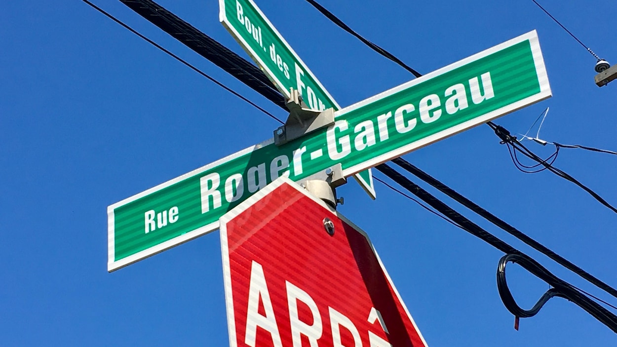 Pancartes de noms de rues sur un panneau d'arrêt.
