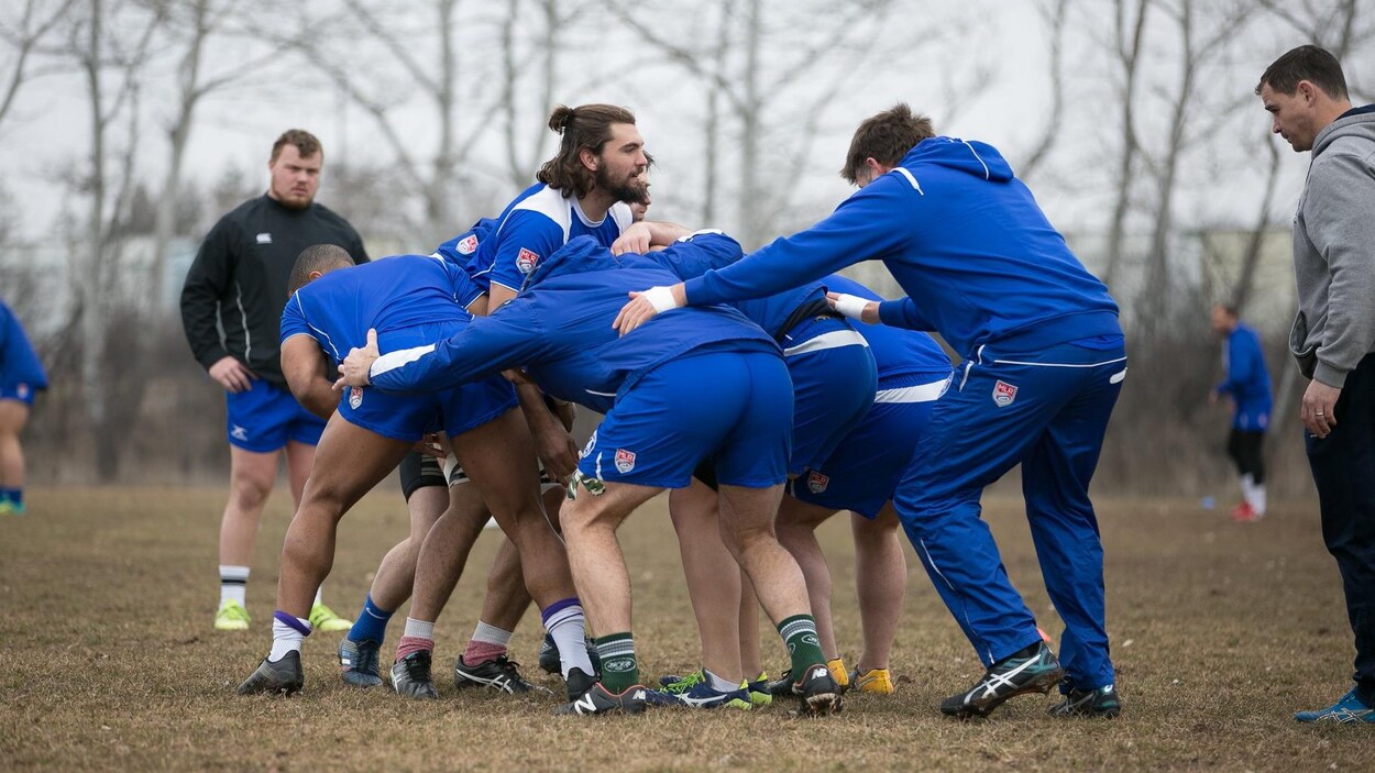 Une équipe de rugby joue à l'extérieur.